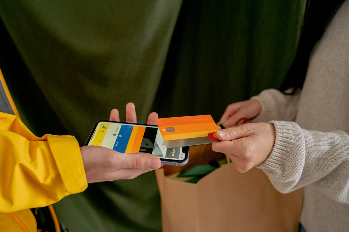 Customer tapping phone to pay contactlessly at a store counter